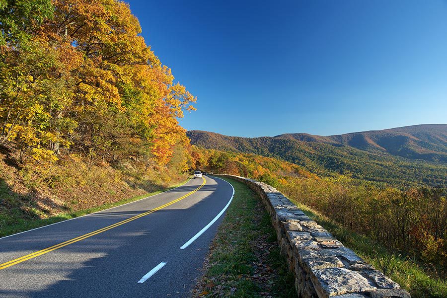 About Our Agency - Winding Road in the Shenandoah Mountains in Autumn, Bright Blue Sky Overhead